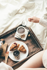 Woman having breakfast in bed. Window light