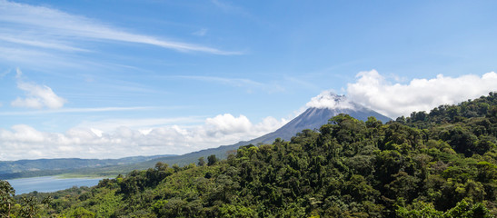 Arenal Volcano and Lake Arenal in Costa Rica as clouds cover part of the landscape.
