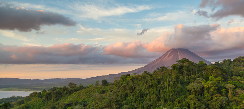 Arenal Volcano at Sunrise in Costa Rica, as the sun reflects on the newly formed clouds