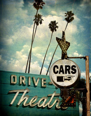 aged and worn vintage photo of drive theater and cars sign with pointing hand © jdoms