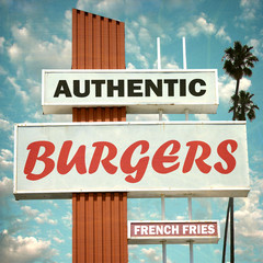 aged and worn vintage burgers and fries sign with palm trees