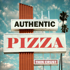 aged and worn vintage photo of authentic pizza sign with palm trees