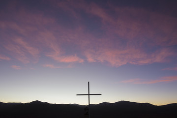 Silhouette of catholic cross in the mountain at sunset, Bolivia
