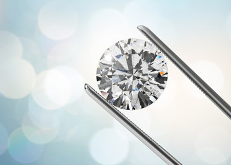 Luxury diamond in tweezers closeup with bright bokeh background - obrazy, fototapety, plakaty