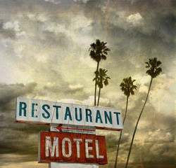 aged and worn vintage photo of retro neon sign with palm trees