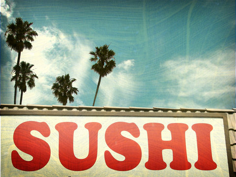 aged and worn vintage photo of sushi sign and palm trees.
