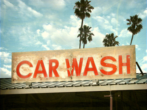 aged and worn vintage photo of car wash sign with palm trees