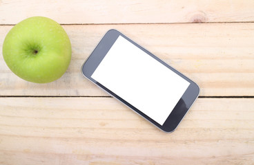 Smartphone and apple on wood table background. Top view with copy space