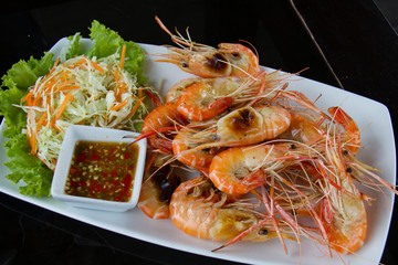 Grilled shrimps on dish with seafood sauce.