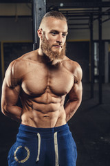 Shirtless muscular man with beard.