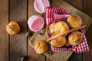 Fruit muffins with nutmeg and allspice in a wicker basket on a wooden background