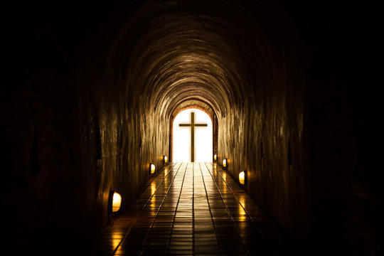 Silhouette of the cross at the end of tunnel.