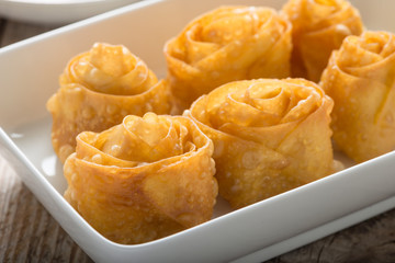 Close-up, Fried wonton flower shape in white dish.