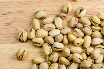 roasted and salted pistachios on wooden background