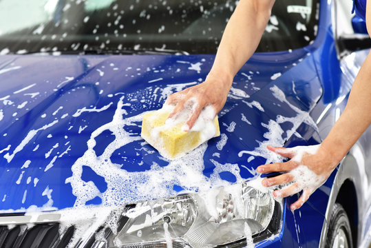 Autowäsche per Hand mit einem Schwamm, professionelle Reinigung einer Motorhaube