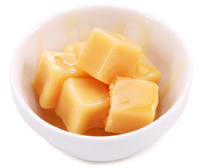Caramel candies in the white dish.