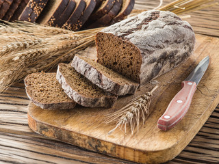 Sliced black bread on the wooden plank.