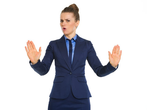 Frowning businesswoman holding hands up to say stop