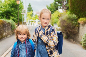 Cute kids with backpacks walking to school