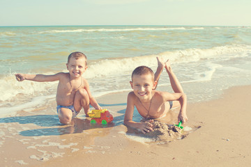 Fototapeta na wymiar Happy Children - two boys having fun on the beach