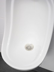 Urinal bowl with stainless strainer in a pristine lavatory, Melbourne, Australia 2015 - 89414743