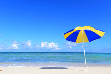 沖縄の青い海とビーチパラソル
