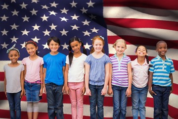 Composite image of cute pupils smiling at camera in classroom