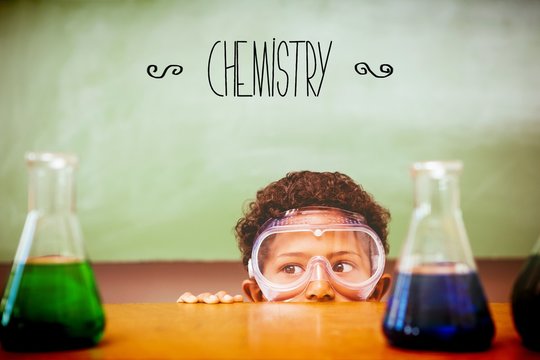 Chemistry against boy looking at conical flasks in classroom