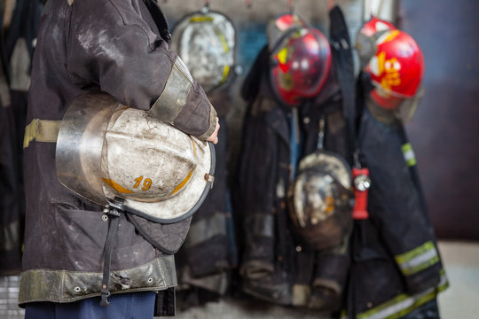 Worker Holding Helmet At Fire Station