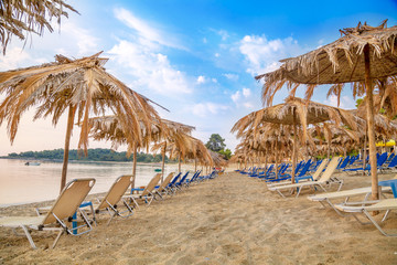 Vivid sunrise on a beautiful sandy beach with sunshade
