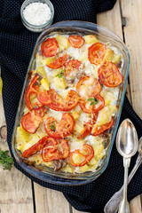 Potato and pork gratin with tomatoes