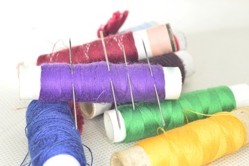 colored threads with needles and blade