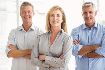 Smiling casual business people with arms crossed