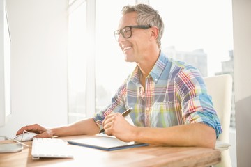 Smiling casual designer using computer and digitizer
