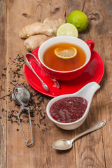 Cup of  tea with ginger,   raspberry jam and lemon