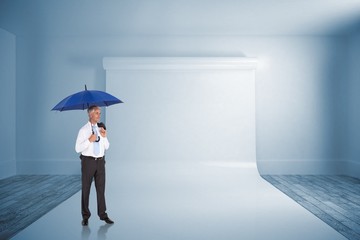 Composite image of happy businessman holding umbrella