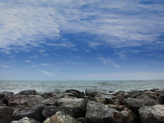 Fototapeta na wymiar Stones on the beach under blue sky