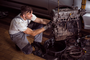 Service station worker repairing motor