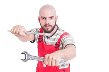 Mechanic or plumber in fighting position with wrenches