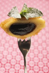 Half a powidl (plum compote) dumpling with buttered crumbs and mint on a fork