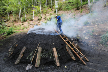 Rauchender Kohlenmeiler im Schwarzwald nach traditionellem Köhler - Handwerk aus  reinem Buchenholz hergestellt