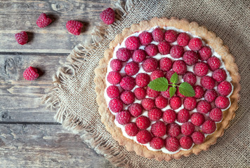 Homemade traditional sweet raspberry tart pie with cream and