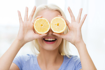 happy woman having fun covering eyes with lemon