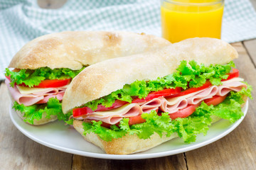 Healthy ciabatta bread sandwiches with ham and cheese on the white plate