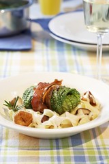 Stuffed savoy cabbage leaf on ribbon pasta with mushrooms
