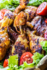 Grilling. Grilled chicken. Grilled chicken legs. Grilled chicken legs, lettuce and cherry tomatoes. Traditional cuisine. Mediterranean cuisine.
