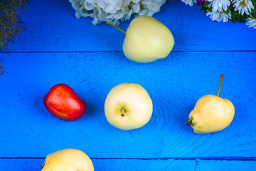 Apples, plum and flowers on a table