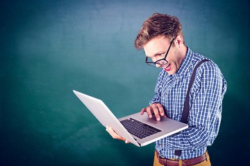 Composite image of geeky businessman using his laptop