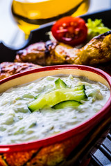 Tzatziki sauce. Tzatziki dressing. Tzatziki dressing with grilled chicken legs and fresh vegetable,lettuce leaf and cherry tomatoes. Grilled chicken legs, lettuce and tomatoes. Mediterranean cuisine.