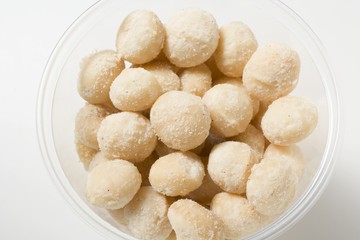 Salted macadamia nuts in plastic tub